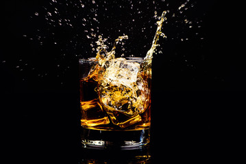 Isolated shot of whiskey with splash on black background