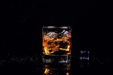 Isolated shot of whiskey with splash on black background