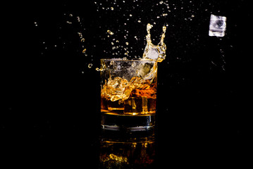 Isolated shot of whiskey with splash on black background