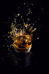 Isolated shot of whiskey with splash on black background
