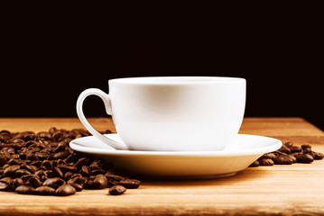 coffee cup, coffee beans on dark background