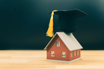 Concept for a smart home. A model house wears a graduation hat.