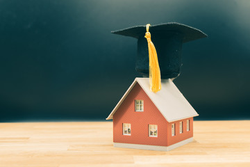 Concept for a smart home. A model house wears a graduation hat.