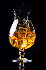 glass with cognac on a black background