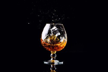 glass with cognac on a black background