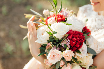 Beautiful bride is holding a wedding colorful bouquet.