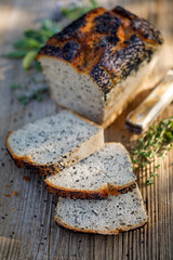 Bread, Rye sourdough bread with the addition of nigella, black caraway seeds cut into slices on a rustic wooden board