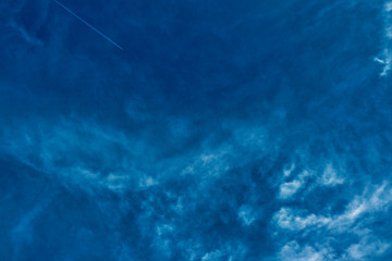 Concept photo of a blue sky background with feather clouds on a sunny day with a dry sun.