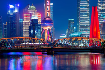Illuminated Shanghai pudong skyline with historical Waibaidu bridge, China during twilight sunset