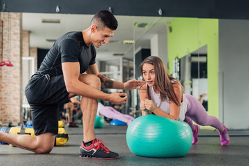 Young woman with personal trainer in the gym