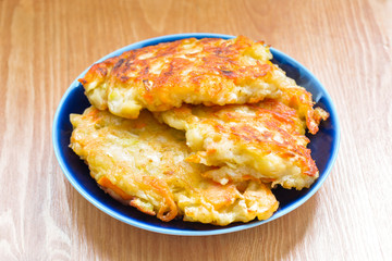 Diet vegetable cutlet from carrot, zucchini, potato on wood table. Healthy food