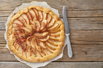 Apple pie, galette with a fruits, sweet pastries on old wooden rustic table, top view, copy space