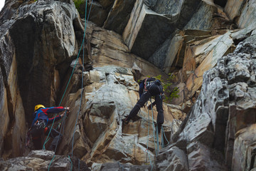 Two climbers work on the route entrenched on a rocky ledge.
