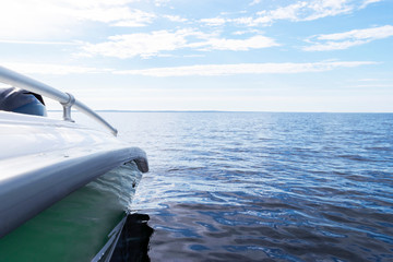 Side view Speeding fishing motor boat with drops of water. Blue ocean sea water wave reflections...