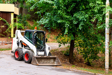 Wheel loader or bulldozer with a bucket in the city park