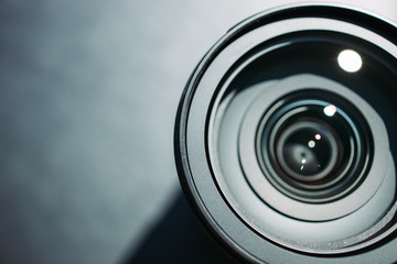 Modern camera lens on dark black background top view