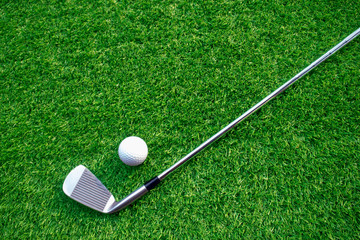 Golf balls and golf clubs on green grass.Golf equipment in the top view.Sports that people around...