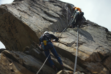 Abstract image of a two person rope of climbers on a rock tower. Tilt-Shift effect.