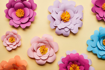 top view of colorful paper cut flowers on beige background