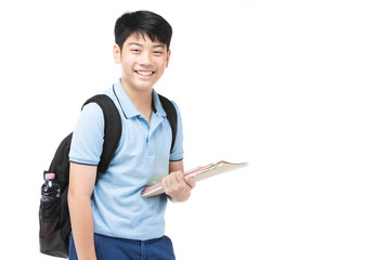 Smiling little student boy in blue polo t-shirt in with books and bag.