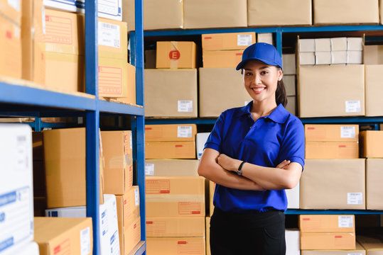 Portrait of woman delivery staff in blue uniform in warehouse