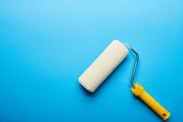 top view of roller on bright blue background with copy space