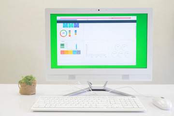 All in one PC on white table with statistics monitor