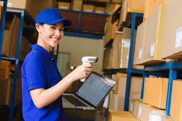 Staff work in warehouse use bar code scanner and laptop with program interface of logistic management