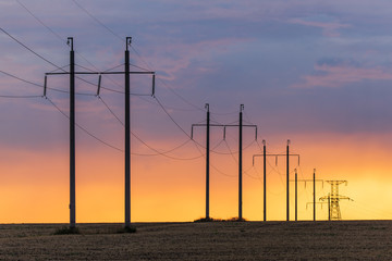Epic sunset with rural landscape with high-voltage line