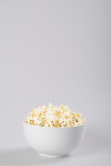 Popcorn in a bowl, isolated on white.