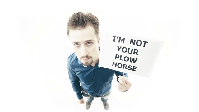 Man holding sign I'm Not Your Plow Horse 4K. Extreme wide shot top view of person head in focus while pull up a sign. White background.