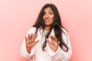 Young indian woman wearing pajama rejecting someone showing a gesture of disgust.