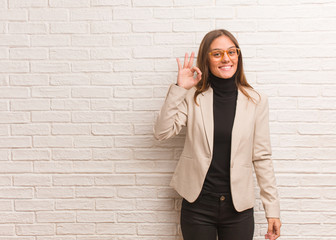 Young pretty business entrepreneur woman cheerful and confident doing ok gesture
