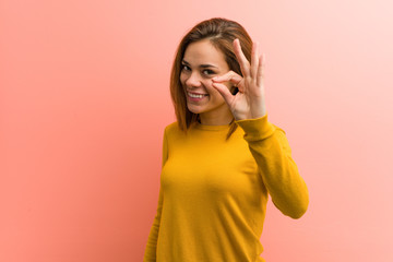 Young pretty young woman cheerful and confident showing ok gesture.