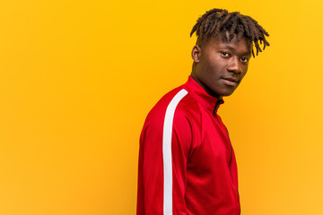 Obraz premium Young fitness black man looks aside smiling, cheerful and pleasant.