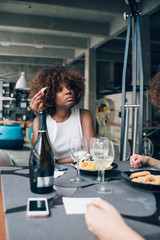 Young woman drinking wine and having food in restaurant