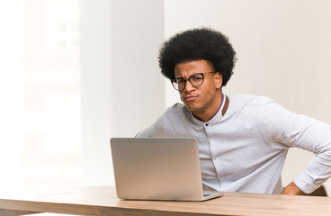 Young black man using his laptop scolding someone very angry