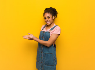 Young black african american girl with blue eyes holding something with hands