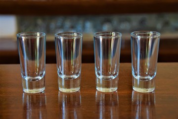 Empty shot glasses lined up on bar indoor
