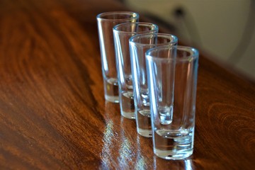 Empty tequila shot glasses lined up on bar indoor