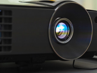 Black projector on black table, close up.