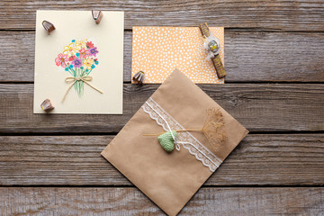 Envelope with white ribbon and two postcards with flowers.