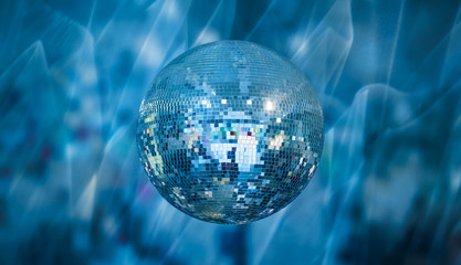 Party disco mirror ball reflecting purple and blue lights 