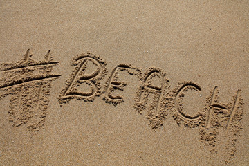 hashtag written by hand in the sand