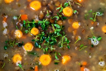 Obraz na płótnie Canvas Detail of surface of lentil soup with carrot.