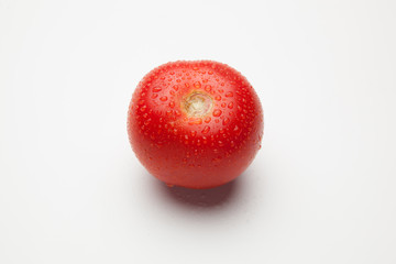 Tomates rojos, sanos y con gotas de agua sobre fondo blanco