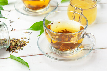 Cup of tea and tea leaves on white wooden table. close up.
