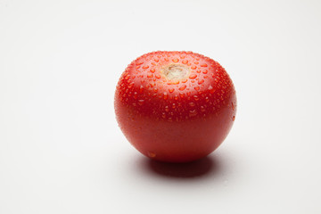 Tomates rojos, sanos y con gotas de agua sobre fondo blanco