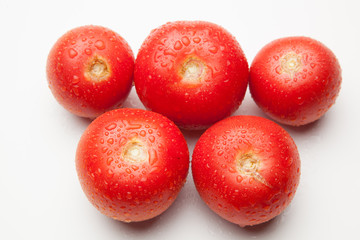 Tomate, rojo, sano con gotas de agua sobre fondo blanco