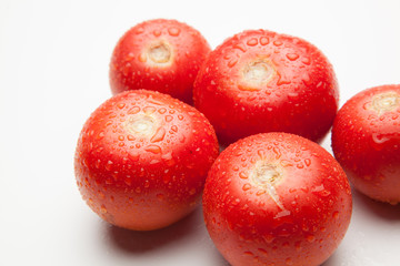 Tomate, rojo, sano con gotas de agua sobre fondo blanco